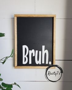 a black and white sign with the word bruh written on it next to a potted plant