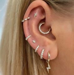 a woman's ear with three different types of piercings