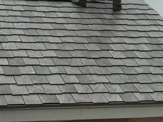 a person on a skateboard is standing on top of a roof that has slate shingles