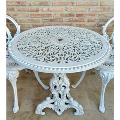 a white table and chairs sitting next to a brick wall