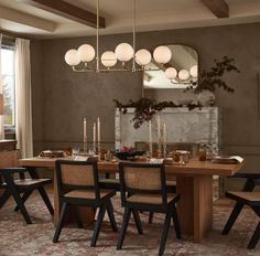 a dining room table and chairs with lights hanging from the ceiling