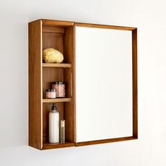 a wooden medicine cabinet with mirror and soap dispenser on it's shelf