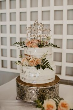 a three tiered cake with flowers on top