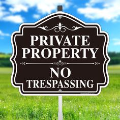 a black and white sign that says private property no trespassing in the grass