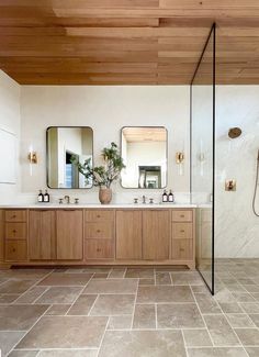 a large bathroom with two sinks, mirrors and a shower in the middle of it