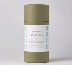 a green tea canister sitting on top of a white table