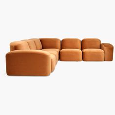 an orange couch sitting on top of a white floor next to a chair and ottoman