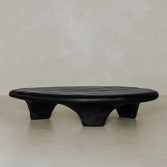 a black bench sitting on top of a cement floor