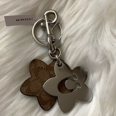 a keychain with a flower on it sitting on top of a furry surface