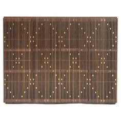 a brown bamboo mat with gold dots on the top and bottom, against a white background