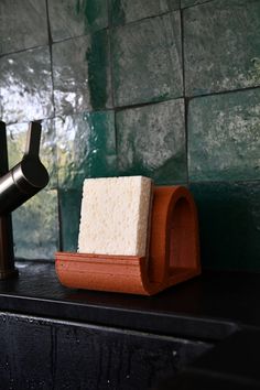 a soap dispenser sitting on top of a counter next to a faucet