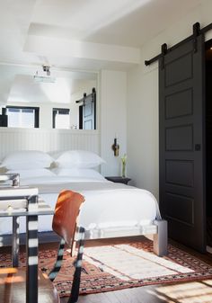 a bed sitting next to a doorway in a bedroom on top of a wooden floor