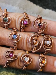 a woman's hand with five different rings on it