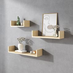 two wooden shelves on the wall with vases and flowers next to each other,