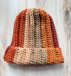 a knitted hat sitting on top of a wooden table