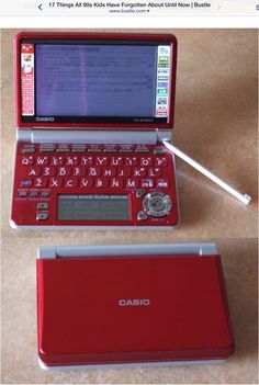 a red laptop computer sitting on top of a table next to a pen and mouse