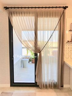 an open door with sheer curtains on the outside and inside, in front of a white tiled floor