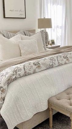 a bed with white sheets and pillows in a bedroom