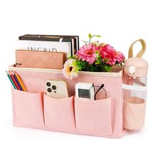 a pink purse filled with lots of items and flowers on top of a white surface