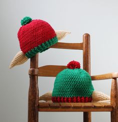 two crocheted hats sitting on top of a wooden chair next to each other