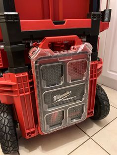 a red and black utility truck with two large tires on the front, attached to it's rear bumpers