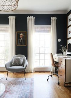 a living room filled with furniture and a painting hanging on the wall above a window