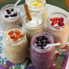 four different smoothies with strawberries and blueberries in them