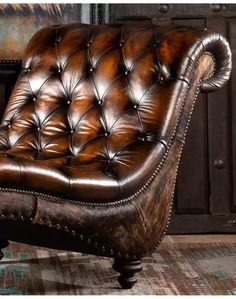 a brown leather chair sitting on top of a rug