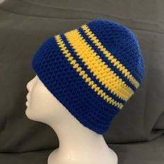 a crocheted blue and yellow hat on a mannequin head