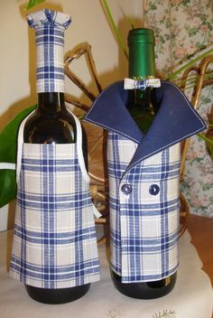 two wine bottles are wrapped in blue and white plaid fabric to look like men's coats