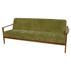 a green couch sitting on top of a wooden frame