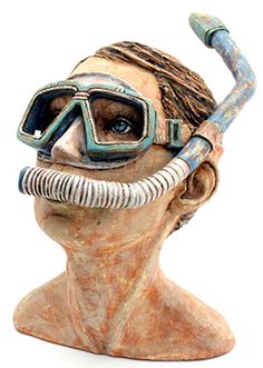 a statue of a man with a diving mask and goggles on his head is shown against a white background