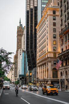 a city street filled with lots of traffic and tall buildings in the evening light hours