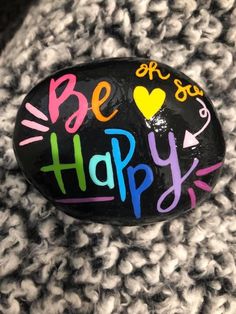 a rock with the words be happy painted on it