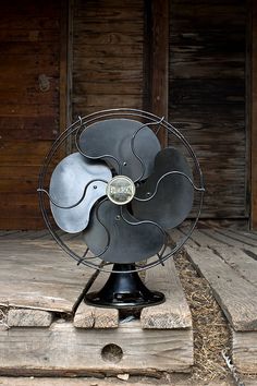 a metal fan sitting on top of a wooden floor