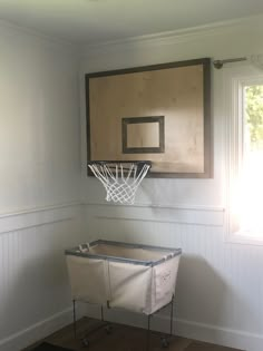 a basketball hoop mounted to the side of a wall in a room with hardwood floors