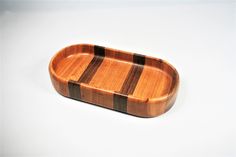 a wooden tray with black and brown stripes on the bottom, sitting on a white surface