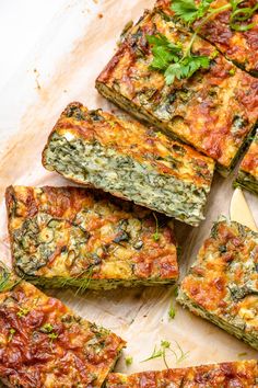 several slices of vegetable pizza on a cutting board next to a knife and napkin with parsley