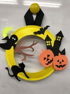 paper plate halloween wreath with black cats and pumpkins