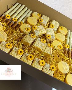 a box filled with lots of yellow and white cookies covered in sunflower frosting