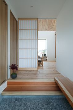 an empty room with wooden steps leading up to the door, and a potted plant on the floor