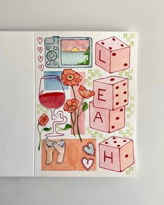 a card with some flowers and dices on the front, next to a glass of wine