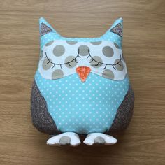 an owl stuffed animal sitting on top of a wooden table