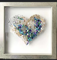 a heart made out of beads in a frame