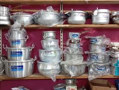 many pots and pans are stacked on shelves