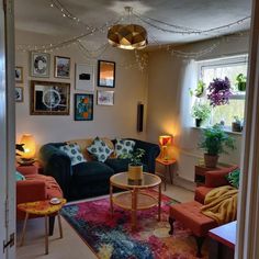 a living room filled with lots of furniture and pictures on the wall above it's windows