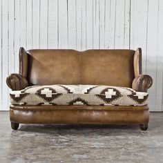 an old leather couch with a southwestern print upholster