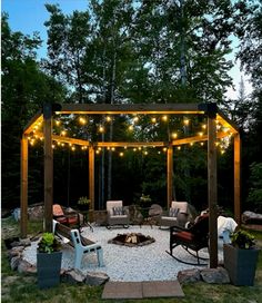 an outdoor fire pit surrounded by chairs and lights