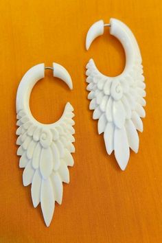 two pairs of white plastic earrings sitting on top of a table