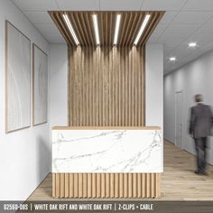 an office lobby with marble counter top and wooden slats on the wall, while a man walks by